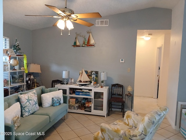 living room featuring light tile patterned flooring, ceiling fan, and vaulted ceiling