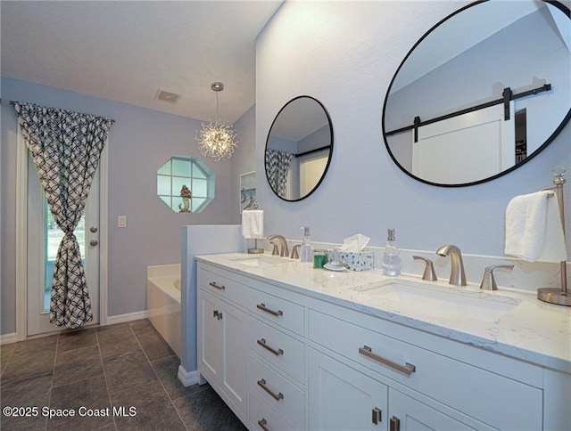 bathroom with baseboards, a bath, double vanity, and a chandelier