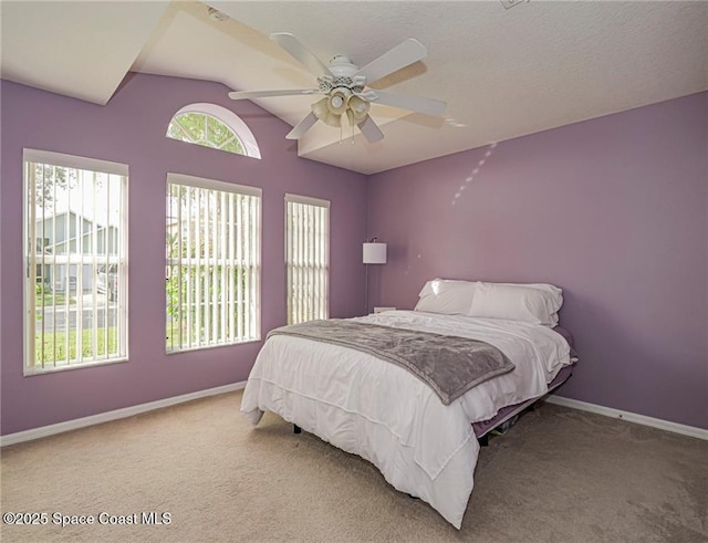 bedroom featuring vaulted ceiling, carpet floors, baseboards, and a ceiling fan
