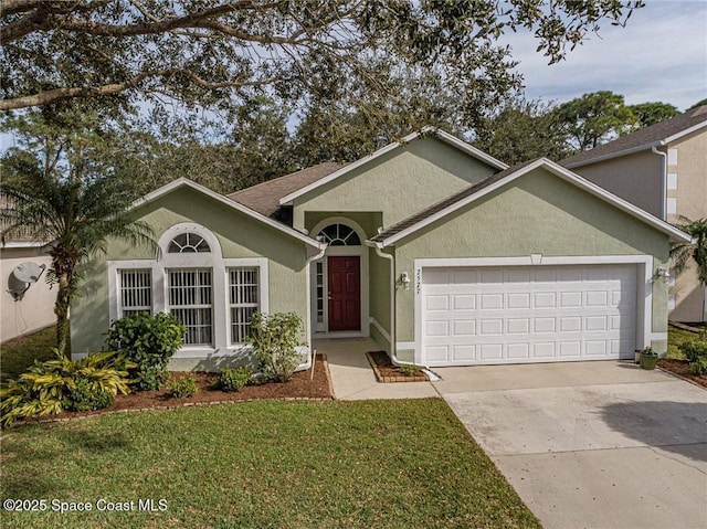 ranch-style house featuring stucco siding, a garage, concrete driveway, and a front lawn