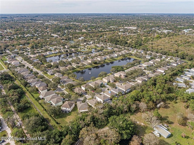 aerial view of property's location with a large body of water and nearby suburban area