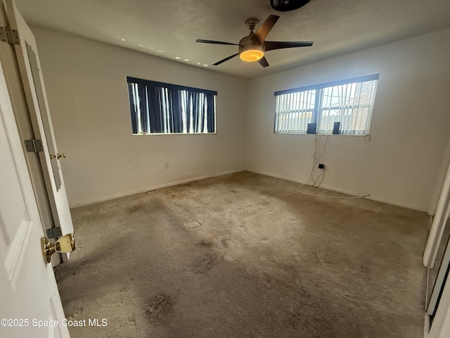 carpeted empty room featuring a ceiling fan