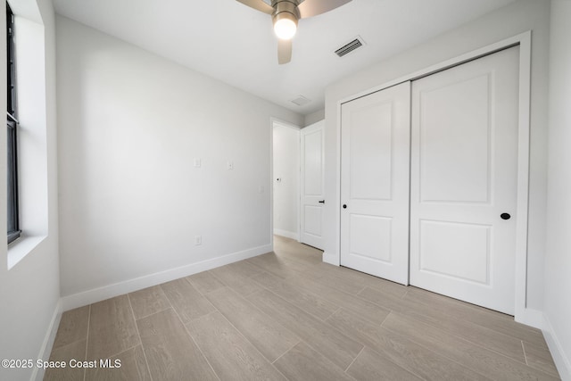 unfurnished bedroom featuring light wood-style flooring, baseboards, a closet, and ceiling fan