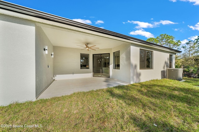 rear view of property with ceiling fan, central AC, a yard, a patio, and stucco siding