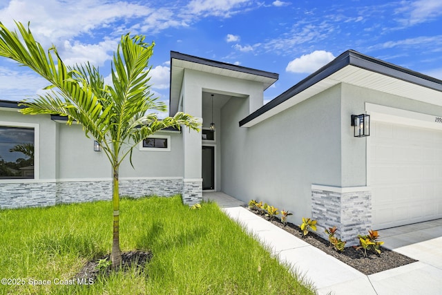 2990 Hackensack Ave SE, Palm Bay, FL 32909 - view of front of house featuring a garage, stone siding, and stucco siding