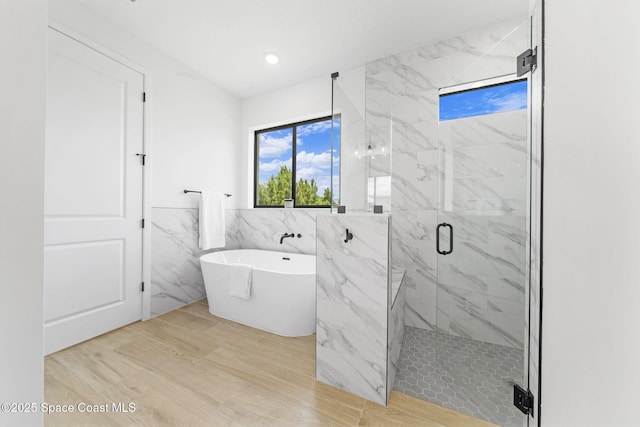 2990 Hackensack Ave SE, Palm Bay, FL 32909 - bathroom featuring a marble finish shower, a soaking tub, tile walls, and wood finished floors