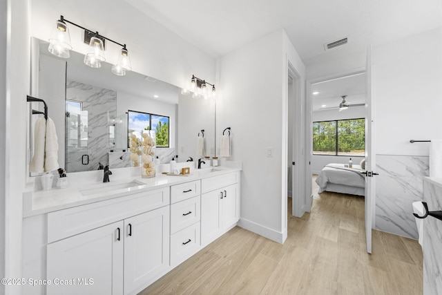 2990 Hackensack Ave SE, Palm Bay, FL 32909 - ensuite bathroom with double vanity, a marble finish shower, ceiling fan, and wood finished floors