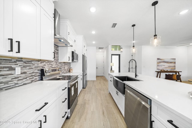 2990 Hackensack Ave SE, Palm Bay, FL 32909 - kitchen with stainless steel appliances, wall chimney range hood, tasteful backsplash, light wood finished floors, and decorative light fixtures