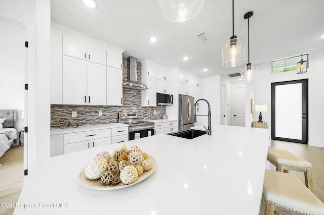 2990 Hackensack Ave SE, Palm Bay, FL 32909 - kitchen with stainless steel appliances, wall chimney exhaust hood, a breakfast bar, tasteful backsplash, and white cabinets