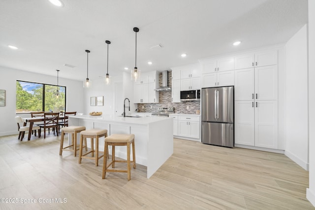 2990 Hackensack Ave SE, Palm Bay, FL 32909 - kitchen with stainless steel appliances, wall chimney range hood, tasteful backsplash, light countertops, and a breakfast bar area