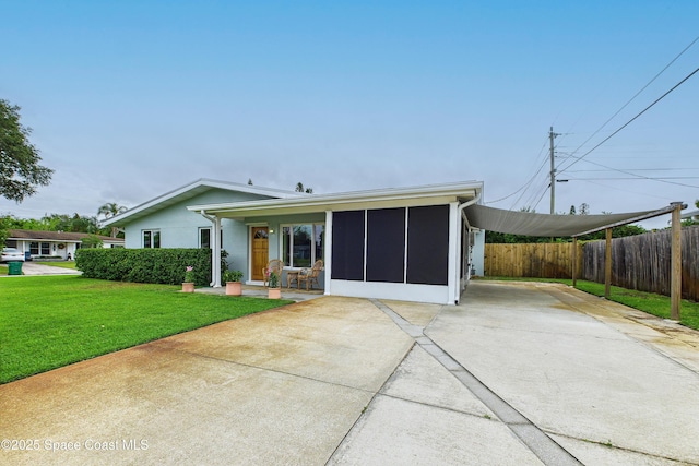 2341 Pawnee Dr, Melbourne, FL 32935 - back of house featuring concrete driveway and a sunroom