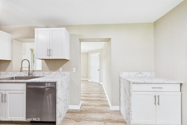 2341 Pawnee Dr, Melbourne, FL 32935 - kitchen featuring stainless steel dishwasher, a sink, light wood-style flooring, white cabinetry, and baseboards