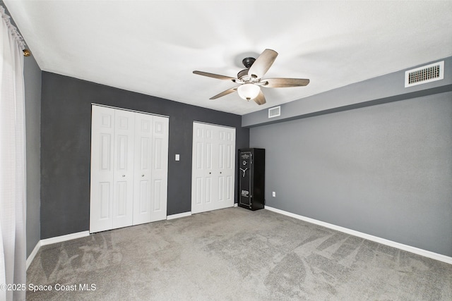 2341 Pawnee Dr, Melbourne, FL 32935 - unfurnished bedroom with two closets, carpet, baseboards, and ceiling fan