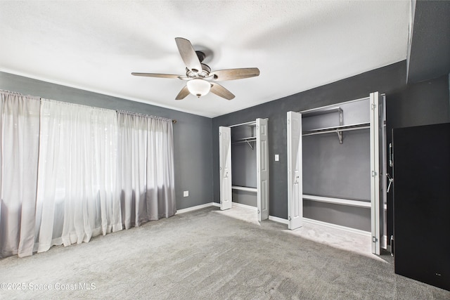 2341 Pawnee Dr, Melbourne, FL 32935 - unfurnished bedroom featuring two closets, carpet flooring, ceiling fan, and baseboards