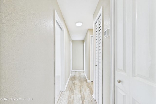 2341 Pawnee Dr, Melbourne, FL 32935 - corridor featuring light wood-type flooring, baseboards, and a textured wall