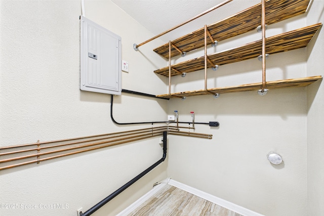 2341 Pawnee Dr, Melbourne, FL 32935 - laundry room featuring light wood-style floors, electric panel, and baseboards