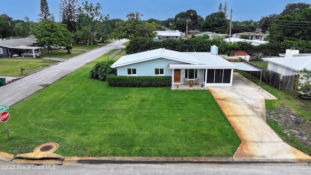 2341 Pawnee Dr, Melbourne, FL 32935 - view of front facade featuring concrete driveway and an attached carport