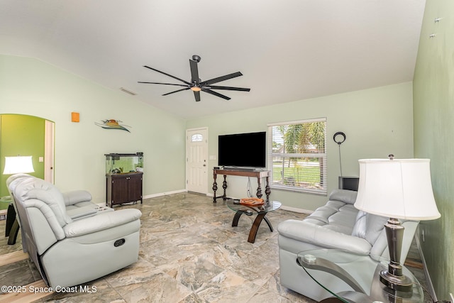 living area featuring vaulted ceiling, baseboards, a ceiling fan, and light stone finish flooring