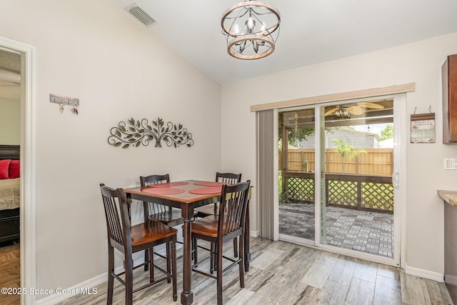 dining space featuring baseboards, light wood-type flooring, and a chandelier