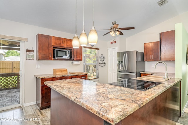 kitchen featuring appliances with stainless steel finishes, ceiling fan, a peninsula, and healthy amount of natural light
