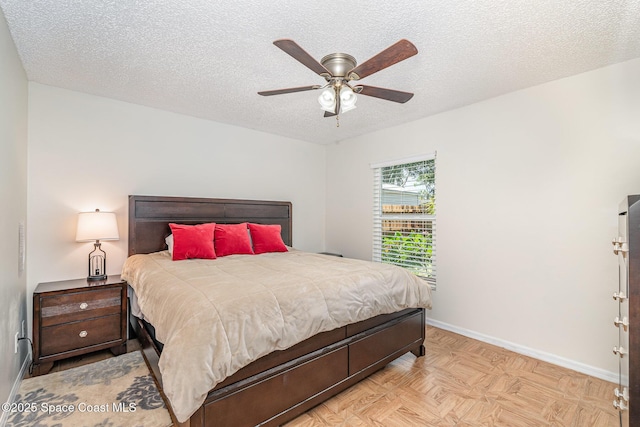 bedroom with a textured ceiling, baseboards, and a ceiling fan