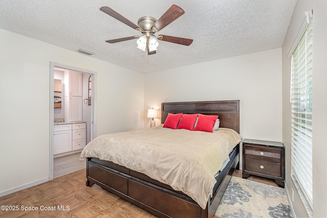 bedroom featuring a textured ceiling, multiple windows, connected bathroom, ceiling fan, and baseboards