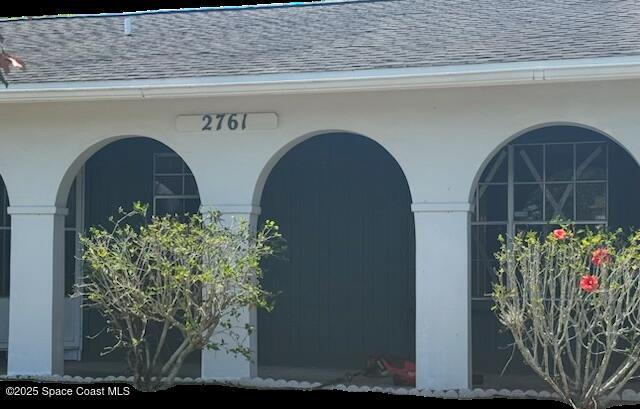 2761 Rhapsody St NE, Palm Bay, FL 32905 - view of exterior entry featuring roof with shingles