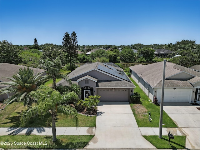 2127 Deercroft Dr, Melbourne, FL 32940 - view of front of house featuring concrete driveway, solar panels, a garage, stucco siding, and a front yard