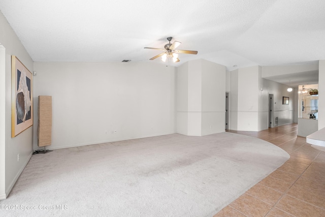 2127 Deercroft Dr, Melbourne, FL 32940 - empty room featuring ceiling fan, lofted ceiling, light tile patterned floors, light carpet, and baseboards