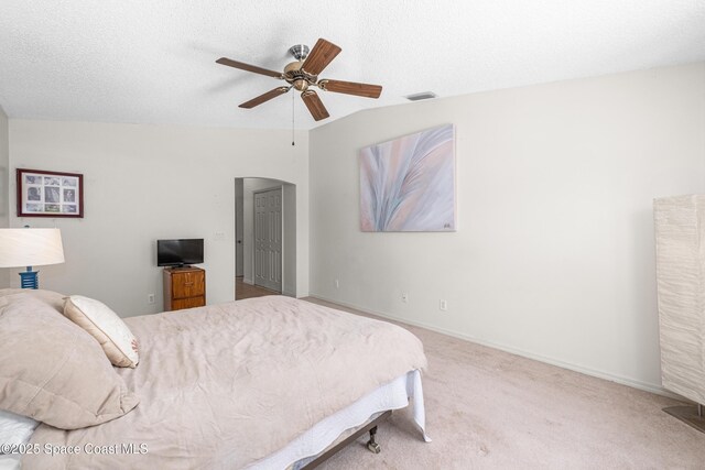 2127 Deercroft Dr, Melbourne, FL 32940 - bedroom with arched walkways, carpet floors, vaulted ceiling, ceiling fan, and baseboards