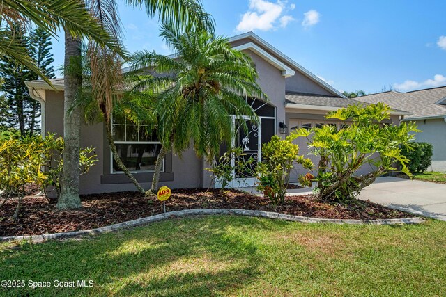 2127 Deercroft Dr, Melbourne, FL 32940 - view of front of property featuring stucco siding, a garage, a front yard, and concrete driveway