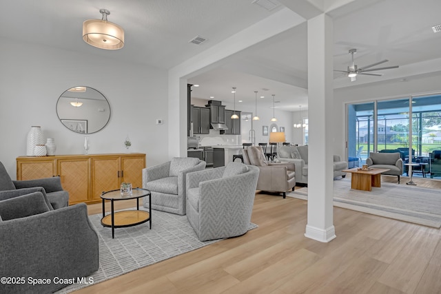 living area featuring light wood-style flooring and a ceiling fan