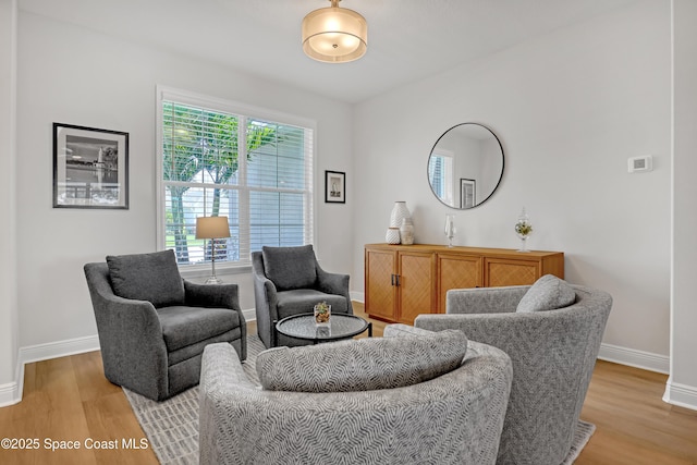 living area with baseboards and light wood-type flooring