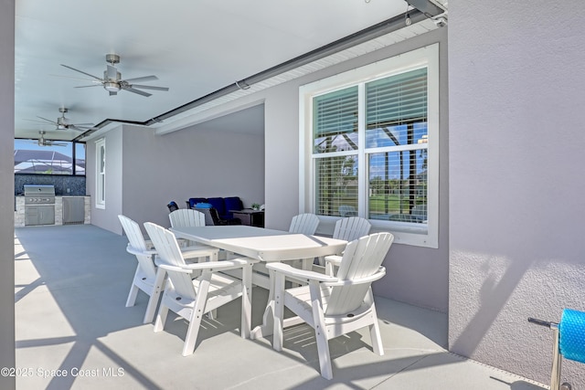 view of patio / terrace featuring ceiling fan, outdoor dining space, exterior kitchen, and area for grilling