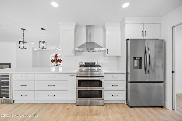 kitchen with stainless steel appliances, wall chimney range hood, beverage cooler, light countertops, and white cabinets