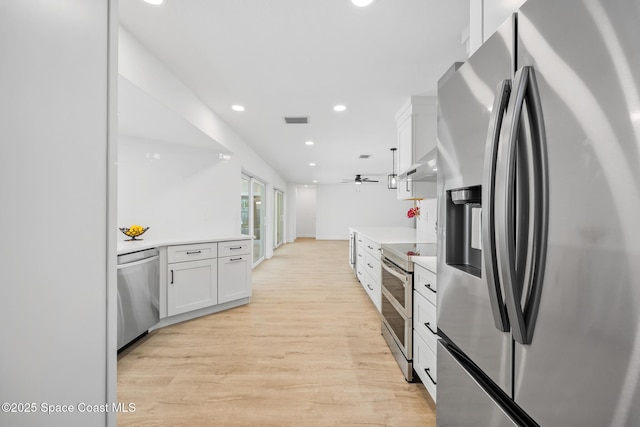 kitchen with stainless steel appliances, white cabinetry, light wood-style flooring, light countertops, and recessed lighting