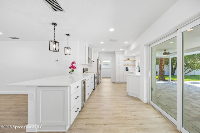 kitchen with open shelves, stainless steel appliances, light wood-type flooring, white cabinetry, and recessed lighting