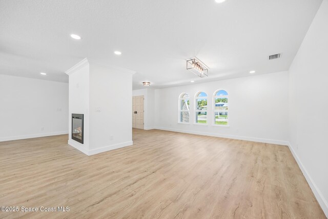 unfurnished living room with recessed lighting, light wood-type flooring, baseboards, and a multi sided fireplace