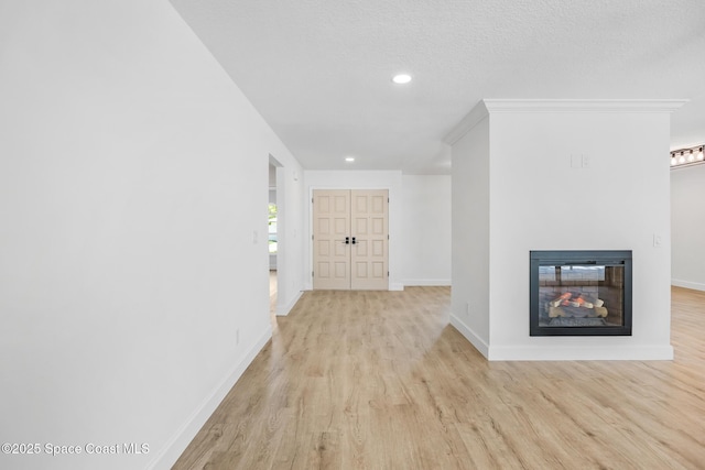 corridor featuring light wood-style flooring, baseboards, and recessed lighting