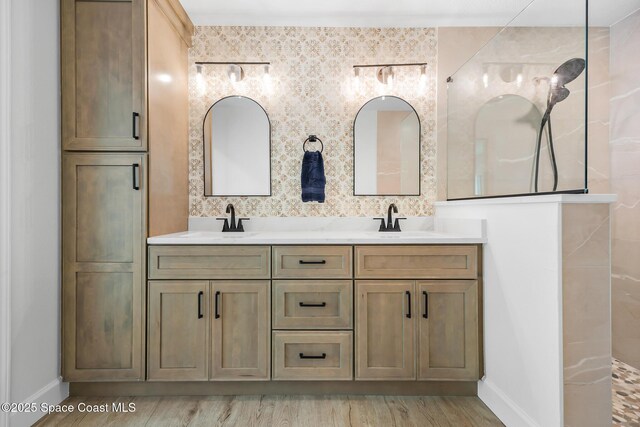 full bathroom with double vanity, a walk in shower, baseboards, wood finished floors, and decorative backsplash