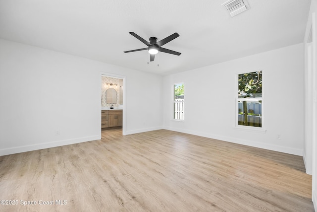 empty room with light wood-style flooring, a ceiling fan, and baseboards