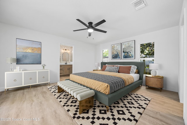 bedroom with wood finished floors, ceiling fan, and ensuite bath