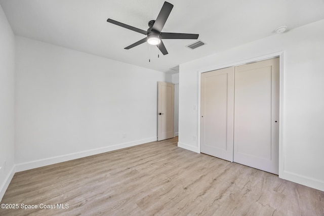 unfurnished bedroom featuring wood finished floors, a closet, baseboards, and ceiling fan