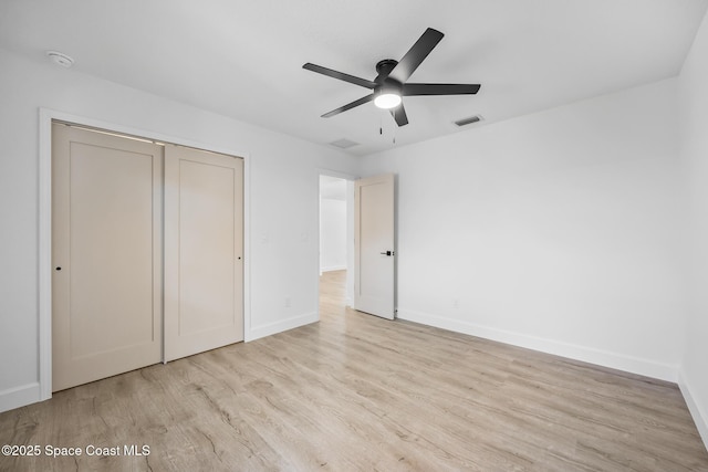 unfurnished bedroom featuring wood finished floors, baseboards, a closet, and ceiling fan