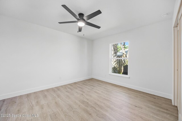 spare room with light wood-type flooring, baseboards, a ceiling fan, and a smoke detector