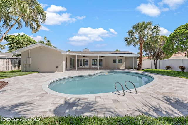 view of swimming pool featuring ceiling fan, fence, and a patio area