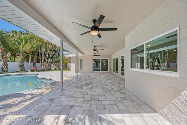 view of swimming pool featuring fence, a patio area, and ceiling fan