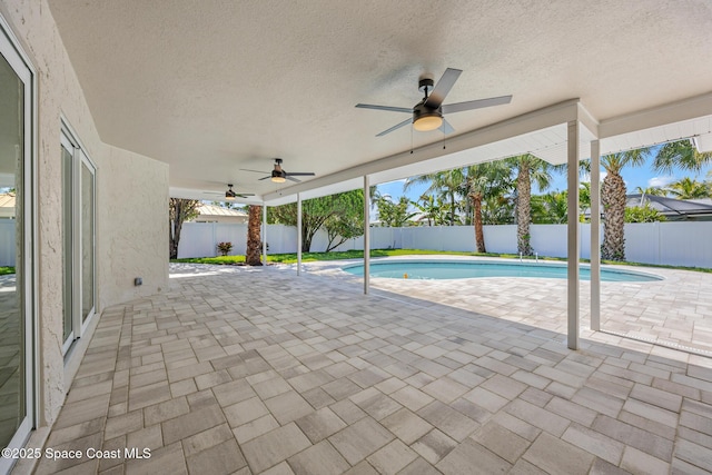 view of pool with ceiling fan, a patio, and a fenced backyard