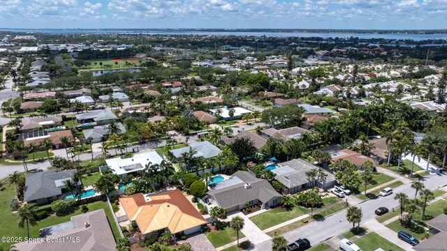 aerial view of property and surrounding area featuring nearby suburban area and a nearby body of water