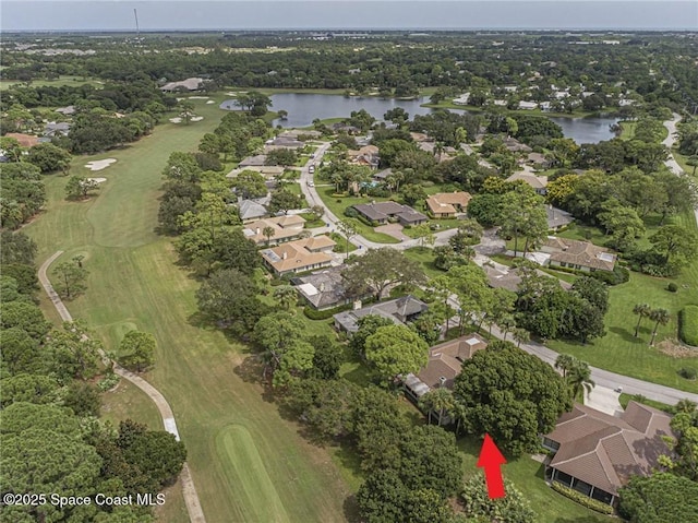 view of property location featuring a large body of water, a local golf course, and nearby suburban area